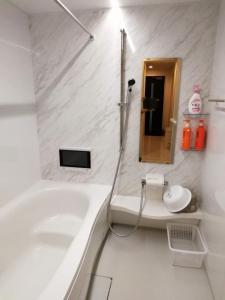 川崎クレアゲハウス新百合ケ丘的白色的浴室设有浴缸和水槽。
