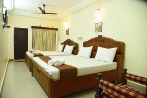 根尼亚古马里Hotel Raja Palace的一间卧室配有两张带毛巾的床