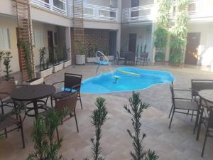 奥林匹亚Casagrande Olímpia Hotel的游泳池,带桌椅的房间