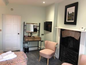 布雷肯Mount Street House的一间卧室设有壁炉、一张床和一张书桌