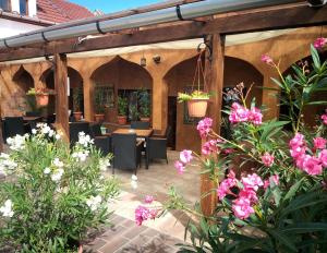埃格尔Hacienda Apartmanok的庭院设有桌椅和鲜花