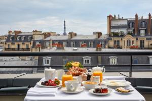 巴黎安贝尔酒店的美景阳台上的餐桌,包括早餐食品