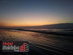通苏帕Hotel Salduba的日落时分海滩的照片,以及saliba酒店的话
