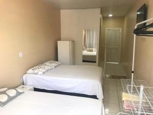 阿尔特杜尚Donaldo Apartamentos的一间卧室设有两张床和一个步入式淋浴间。