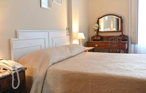 蒙得维的亚帕拉西奥酒店的一间卧室配有床、镜子和梳妆台