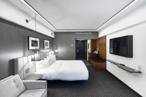 蒙特利尔蒙特利尔文德酒店的配有一张床和一台平面电视的酒店客房