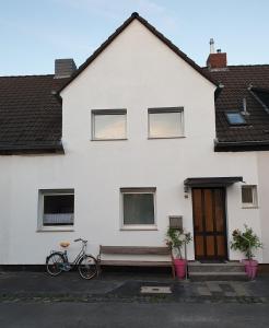 杜塞尔多夫Home-Rose-Garden-Gästehaus kontaktloser Zugang的两辆自行车停在白色房子前面