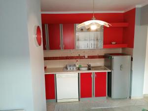 Gornje VratnoApartman Obadić的厨房配有红色橱柜和白色冰箱