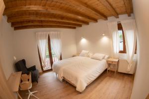 ColioApartamentos Los Picos de Europa的一间卧室设有一张大床和两个窗户。