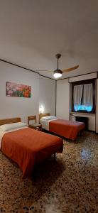 Bussoleno伊索拉贝拉酒店的一间卧室配有两张床和吊扇