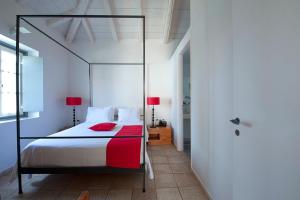 斯派赛斯奥尔洛夫度假酒店的一间卧室配有一张带红色枕头的天蓬床