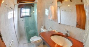 格拉玛多Hotel Aconchego da Serra的一间带水槽、淋浴和卫生间的浴室