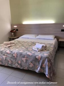 西尔米奥奈Ohana Apartments Camping Tiglio的一间卧室配有一张带粉红色鲜花的大床