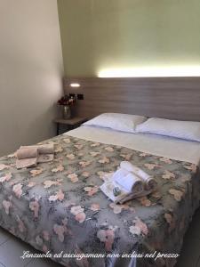 西尔米奥奈Ohana Apartments Camping Tiglio的一间卧室配有一张床,上面有两条毛巾