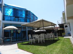 塔克纳Arenas Hotel & Spa的一组椅子和遮阳伞在建筑前