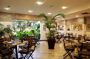 瓜鲁雅格兰德之家Spa度假村的餐厅设有桌椅和大窗户。