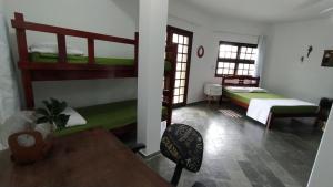 伯迪亚哥Casanapraia Bertioga的客房设有两张双层床和一张桌子。