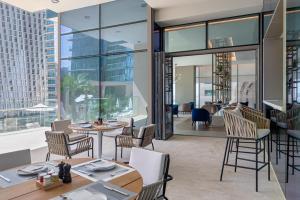 迪拜Jumeirah Living Marina Gate Dubai的一间带桌椅的市景餐厅