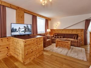 蒂罗尔-泽费尔德西弗德霍夫酒店的客厅配有平面电视和沙发。