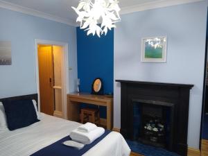 布里德灵顿克罗默旅馆的蓝色卧室设有一张床和一个壁炉