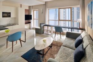 迪拜Mövenpick Hotel Apartments Downtown Dubai的客厅配有沙发和桌子