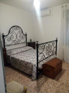 Castel del RioB&B ca'del grillo的一间卧室配有一张黑色的床和一张木桌