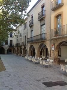 班约莱斯PLAÇA MAJOR 17 2n 1a的一座庭院,位于一座带桌椅的建筑中