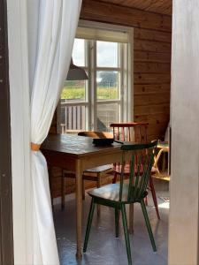 乌尔夫堡Fjand Badeby - Guesthouse, Cottages and Colony的一间带桌椅和窗户的用餐室