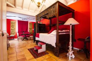 塔扎克蒂Hotel Hacienda de Abajo-Adults Only-Lujo的一间卧室设有天蓬床和红色墙壁