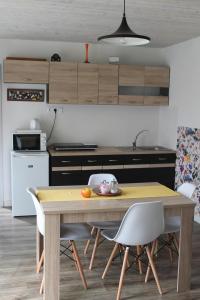利普托斯基米库拉斯Malina - AND Apartment的厨房配有木桌和椅子
