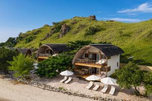 Sebayur科莫多度假酒店的海滩上的2间小屋 - 带遮阳伞和椅子