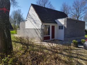 辛佩尔费尔德Belle - Mooi Zuid Limburg的一间白色的小房子,有红色的门