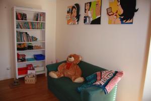 德韦灵阿普Chuditch Holiday Home Dwellingup - Great Central Location的坐在一个房间里绿沙发上的泰迪熊
