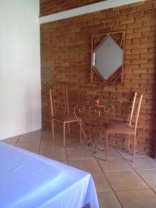 佩尼多Vilarejo Penedo Chalés的砖墙上一张桌子和两把椅子及一面镜子