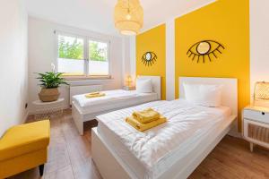 德累斯顿Apartment Elbkiez的一间卧室设有两张床和黄色的墙壁