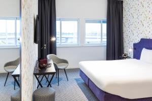 史基浦ibis Styles Amsterdam Airport的酒店客房,配有床和椅子