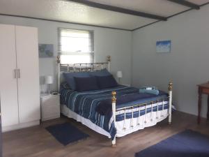 斯托姆勒菲Nadine's Self - Catering Accommodation的一间卧室配有一张带蓝色床单的床和一扇窗户。