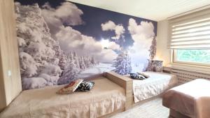 科帕奥尼克Apartments KOP Konaci的一间带两张床和雪壁画的卧室