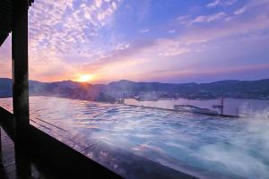 长崎Ooedo Onsen Monogatari Nagasaki Hotel Seifu的一座大型游泳池,背靠日落