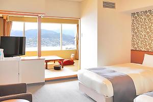 长崎Ooedo Onsen Monogatari Nagasaki Hotel Seifu的一间卧室配有一张床和一张书桌及电视