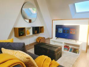 蒙斯Yellow Studio的带沙发、电视和镜子的客厅