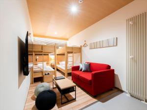 俱知安町TORIFITO HOTEL&POD NISEKO的客厅配有红色的沙发和双层床。