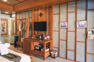 清迈武里府画廊饭店的一间设有床铺和墙上电视的房间