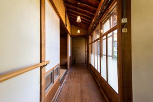 AkiHostel 東風ノ家（Kochi-no-ya）的走廊上设有木地板和窗户,位于大楼内