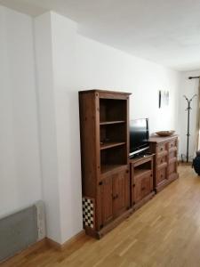 布罗托Completo Broto的一间带电视和木柜的客厅