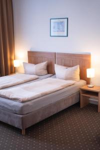 斯图加特豪斯特格潘森酒店的配有2盏灯的酒店客房的2张床