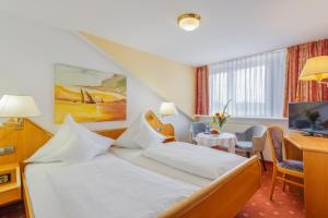 巴特克罗青根伊甸酒店的配有一张床和一张书桌的酒店客房