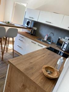 姆拉代布基Apartmán Mladé Buky的厨房配有白色橱柜和木制台面