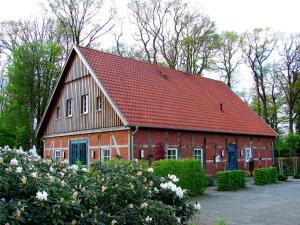 LöningenDZ/EZ Lodberger Scheunencafe的红谷仓,有红色的屋顶和一些花