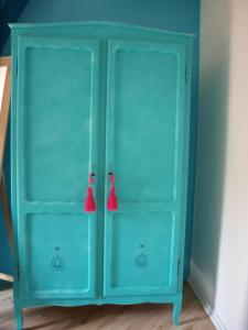 亨克Slaaphuisje Het vliegend varken的蓝色的橱柜,有两扇门和红色的容器